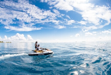 Ein Mann fährt auf einem Jetski im Meer.